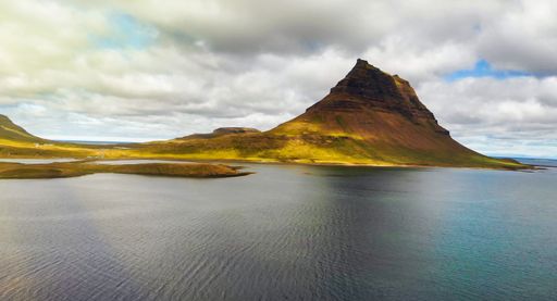 A closeup of the famous Icelandic mountain Kirkjufell with lake and ocean in the background