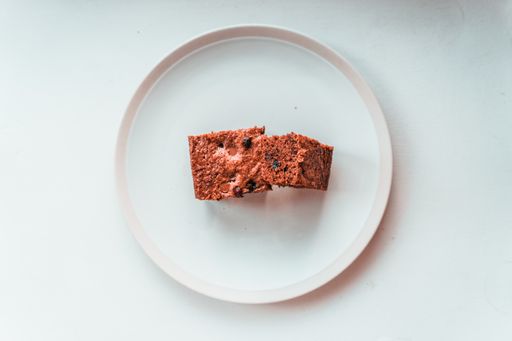A closeup shot of a delicious brownie with blueberries in a white plate