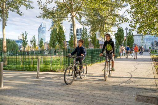 The boys riding bicycles at "Library of Trees" city park in Milan, Italy