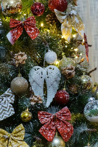 A vertical closeup of the Christmas decorations on the tree.