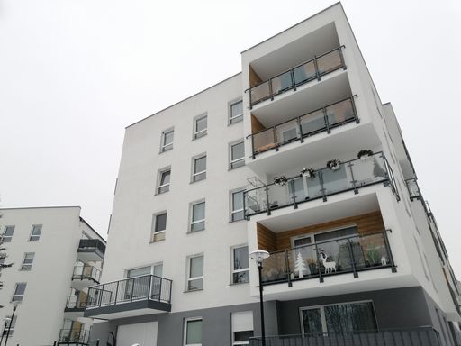 A vertical shot of an apartment building with Christmas decorations in the balconies in Poznan, Poland