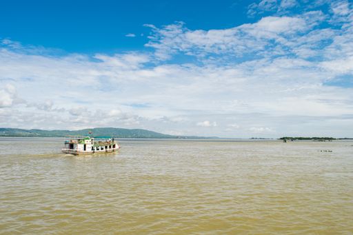 A boat crossing Irrawaddy River, between the city of Mandalay and Mingun, on a cloudy summer day during monsoon season, Myanmar, Burma.