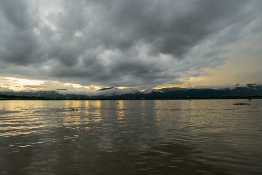 Panoramic view of Inle Lake and the surrounding mountains and countryside at sunset on a cloudy and rainy monsoon day. Myanmar, Burma, SE Asia