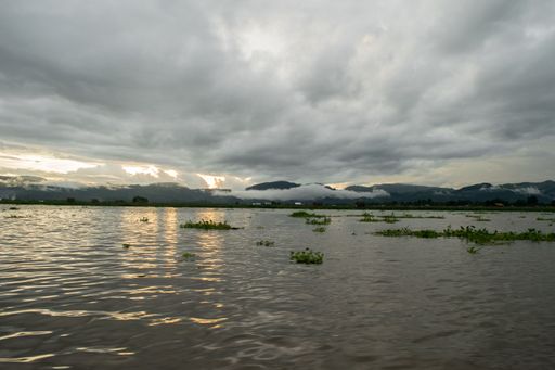 Panoramic view of Inle Lake and the surrounding mountains and countryside at sunset on a cloudy and rainy monsoon day. Myanmar, Burma, SE Asia