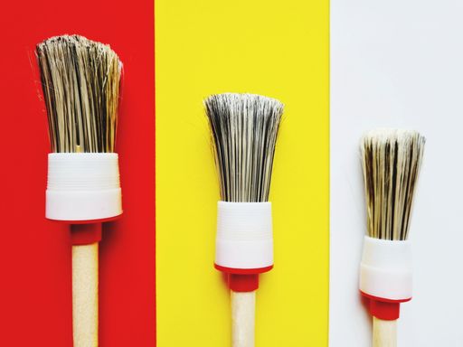 A close-up of brushes of different sizes isolated on colored backgrounds