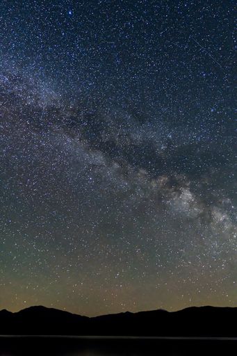 A vertical shot of the Milky Way over silhouettes of hills