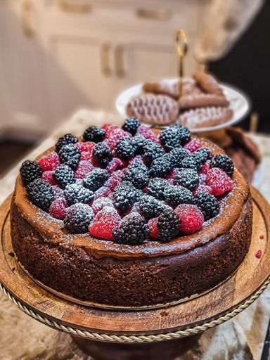 A selective focus shot of a tasty homemade cheesecake with blackberries and raspberries on top