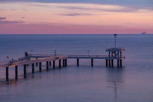 A stunning view of the famous Burgas sea bridge against a dramatic orange and purple sunset sky