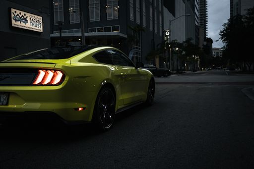 A lime green Ford Mustang parked on a street downtown in Fort Lauderdale FL