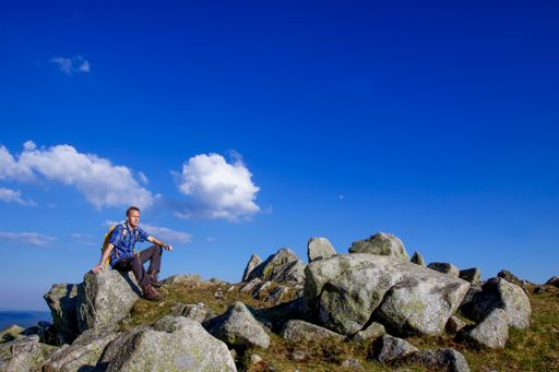 A male hiker sitting on the rock on Feldberg mountain in the Black Forest