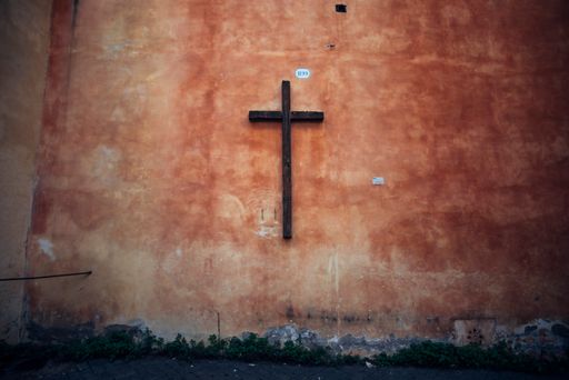 A wooden cross on a stone wall in Rome, Italy