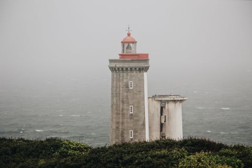 A lighthouse with a red top and the beautiful sky