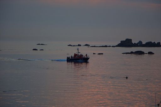 A small boat in the sea during the sunset