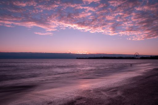 A scenic view of the coastline against the seascape reflecting the purple sunset