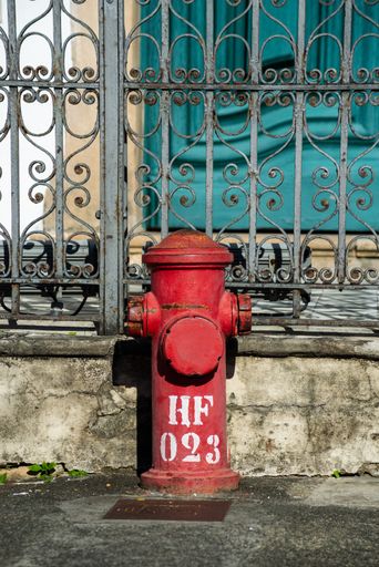 A vertical closeup of an old red fire hydrant in the streets of Pelourinho, Salvador, Bahia, Brazil
