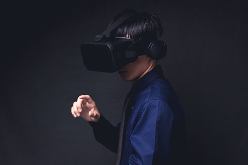 A young Asian man wearing virtual reality glasses