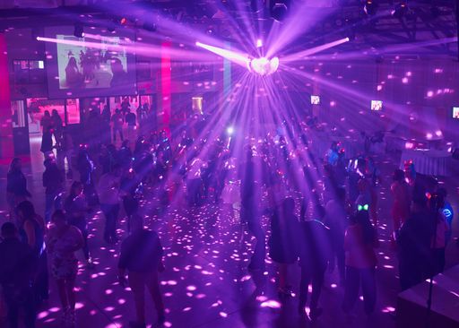 Some people are dancing in the club with neon lights.