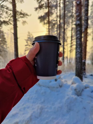 A closeup of a hand with a takeaway cup