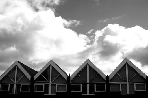 A low angle closeup of small modern houses next to each other in greyscale