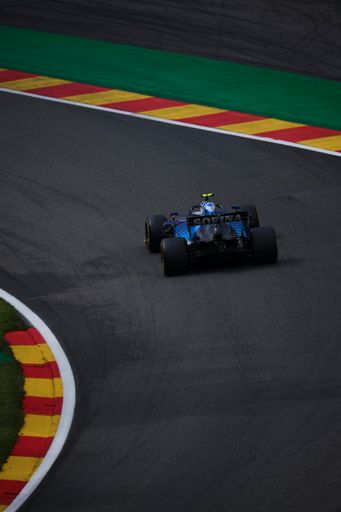 A vertical shot of a Ferrari formula 1 truck on the road at Circuit de Spa-Francorchamps.