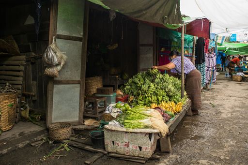 A stall of fresh fruit and vegetable food vendor, in Nyaung shwe market, near Inle Lake, Myanmar, displaying crates of fresh farm produce and crops.