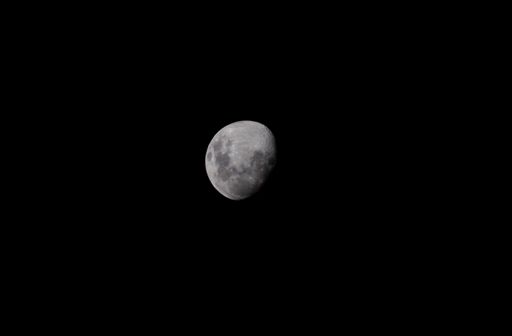 A low angle shot of the magnificent moon captured in the dark night sky