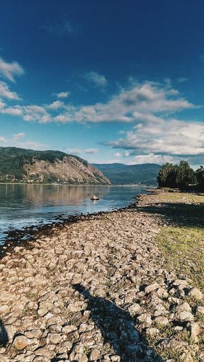 A vertical shot of a river beach with lots of small rocks