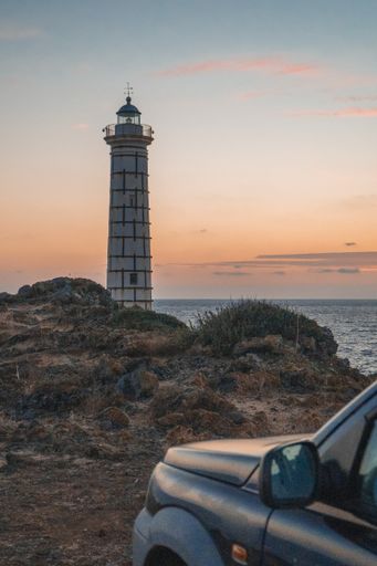 A vertical shot of the lighthouse of Punta Cavazzi in Ustica, Italy against a colorful evening sky