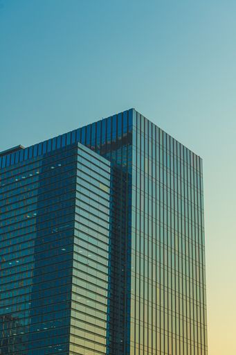 A vertical low angle shot of a glass building under the blue sky captured in Seoul, South Korea