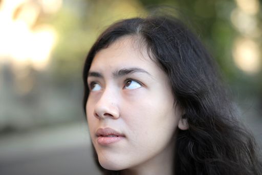 A selective focus shot of pretty female with black hair looking up