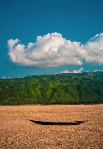 A vertical shot of a wooden boat on the drought with green mountains in the background, Sylhet,