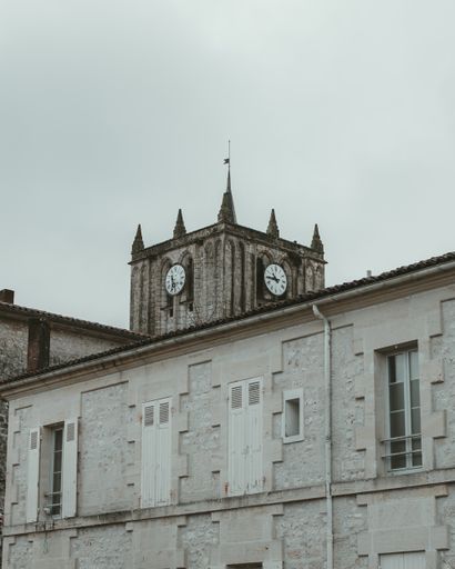 A vertical shot of the bell tower of Saint Savinien Charent against cloudy sky, France