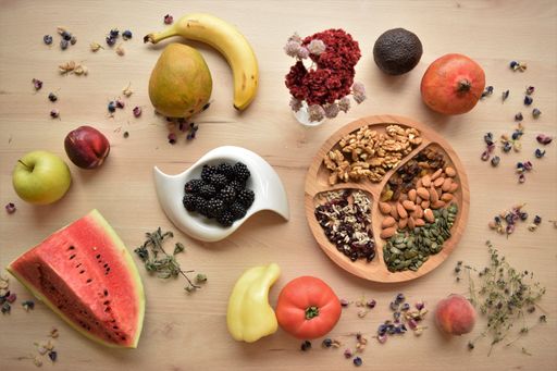 A top view of mixed  seeds, nuts, and fruits on a wooden table