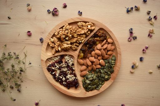 A top view of mixed seeds and nuts served on a wooden plate
