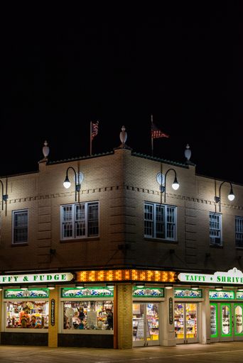 A picturesque nighttime scene of a Shriver's Candy Store with a glowing sign