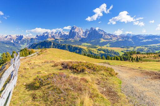 A family sitting and watching the panoramic Dolomites during a hike on Alpe Siusi