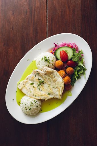 A vertical shot of chicken breast with rice, potato croquettes and vegetabl