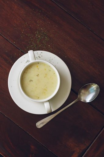 A vertical shot of sour potato soup isolated on the brown table background
