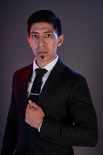 A portrait of an Asian tango dancer against a gray wall