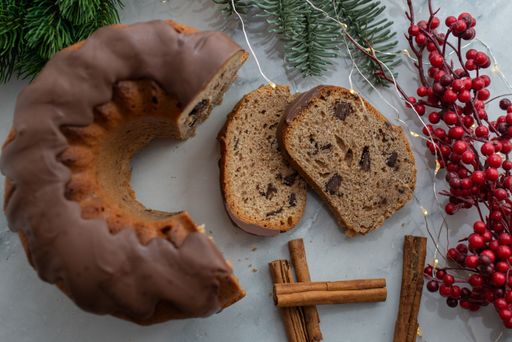 A top view shot of slices of Christmas chocolate bundt cake, cinnamon, and Holly decorations