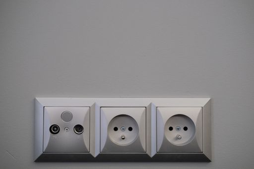 A closeup shot of three plugs on a wall