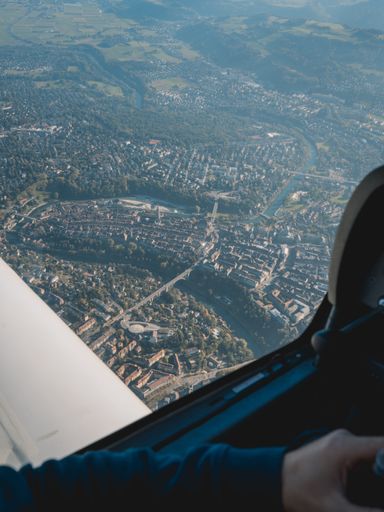A vertical shot of a landscape and a city seen from an airplane