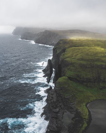 An aerial view of waving ocean in Gasadalur Faroe Islands