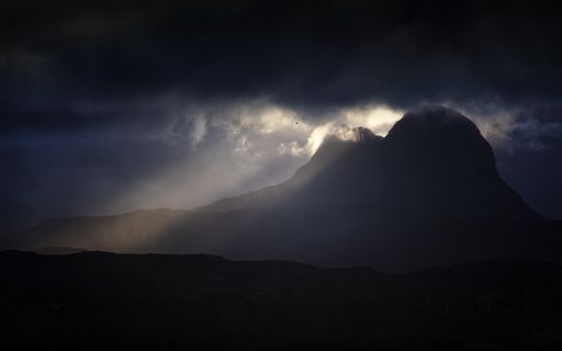 Sunrise in Assynt: dark clouds, vibrant sunlight over Suilven