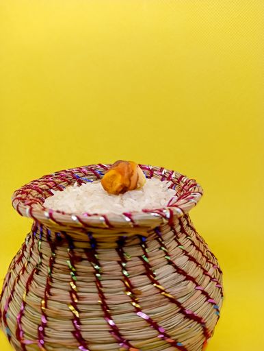 Kusha grass made pot with rice and ginger. Pot is made by hand and used in may worships.