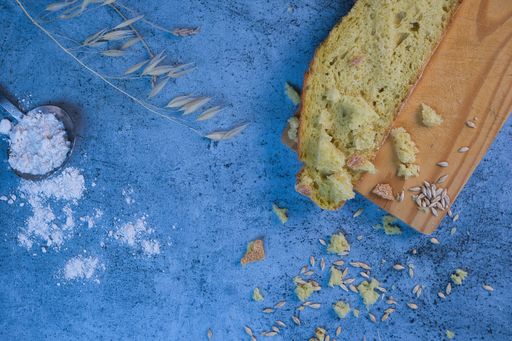 A closeup shot of bread, wheat and flour on a blue surface