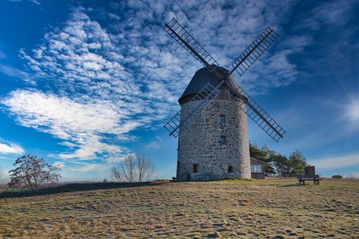 A windmill in the field in the daytime.