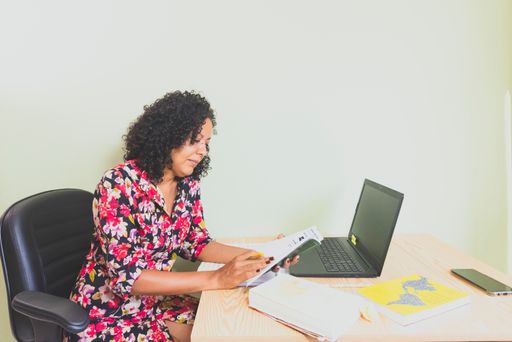 A portrait of a woman sitting working remotely from her home