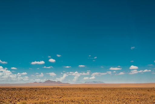 A horizontal shot of landscape at the Namib desert in Namibia under the blue sky and white clouds