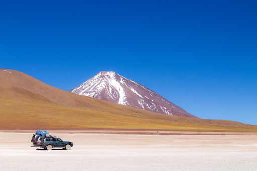 A beautiful shot of off road vehicles under Licancabur volcano in Bolivia